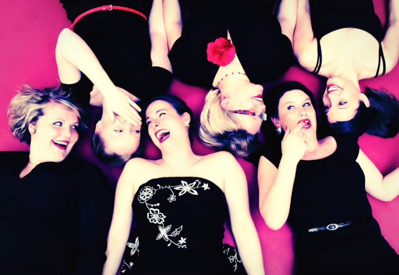 Junggesellinnenabschied Fotoshooting Freunde 6 Mädels liegen auf dem Rücken roter Hintergrund